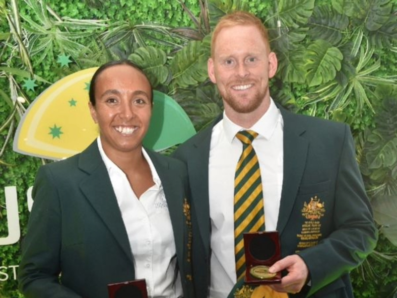 Jake Smith smiling with his captaincy cap and fellow captain